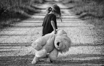 Ребенок с плюшевой игрушкой в руке