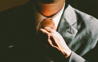 бизнесмен поправляет галстук