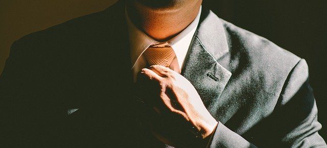 бизнесмен поправляет галстук