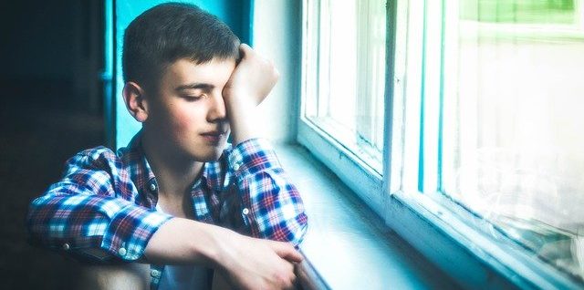 парень сидит у окна