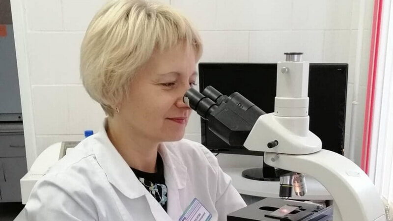 врач за микроскопом