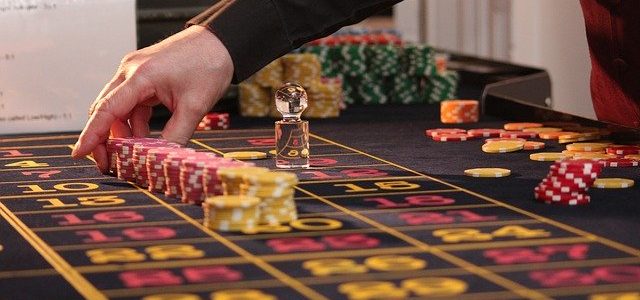 рука крупье раскладывает фишки