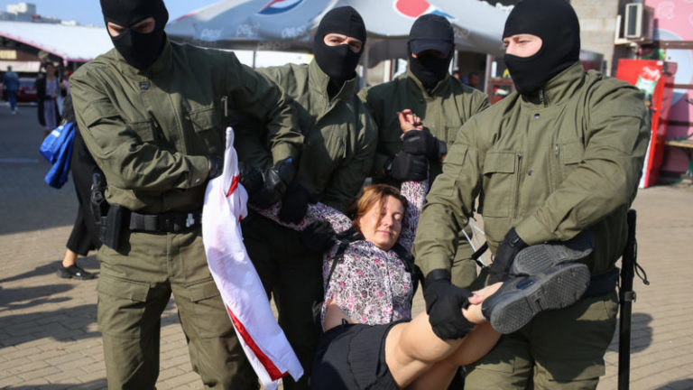 протесты в Минске несут женщину