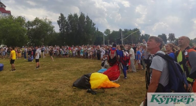 Зрители смотрят за прыжками с парашютом